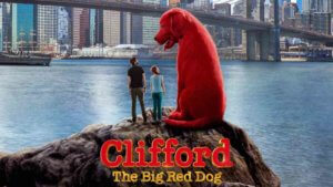 Two people stand beside a giant red dog on a rock in front of new york skyline