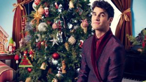 Darren Criss in front of a Christmas tree