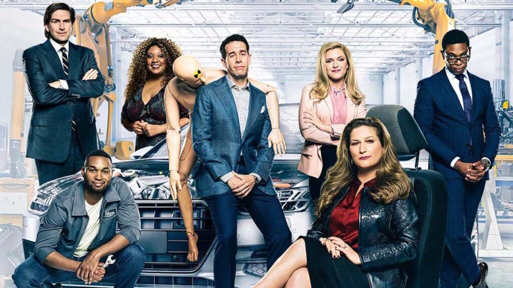 The cast of American Auto in a car factory
