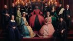 The cast of Anne Boleyn in tudor attire surrounding Anne on the throne