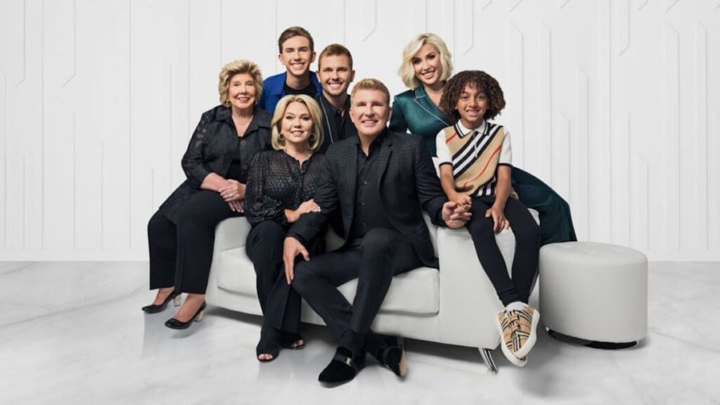 The Chrisley family seated together in a white studio space