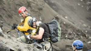 Will Smith in climbing gear with explorer on side of volcano