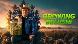 Actor Jim Belushi holding a jar of marijuana in a pot field.