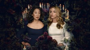 Two women surrounded by flowers and candles