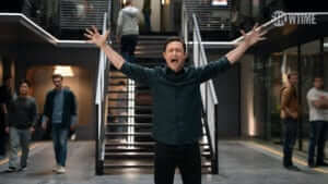 a man stands in front of a posh building elevator with his arms thrown out