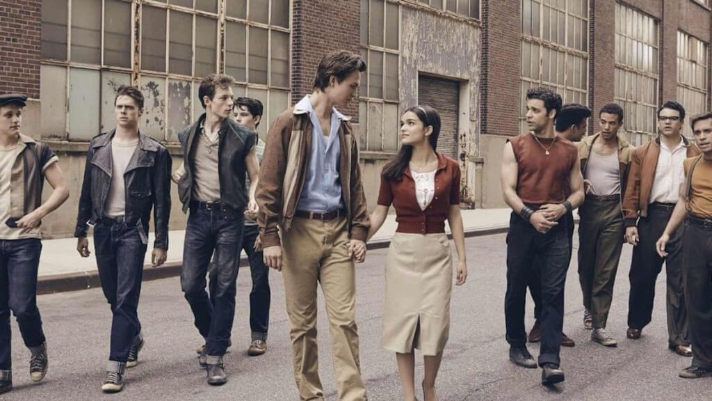 Two groups of teens on a New York Street with a young couple holding hand between them