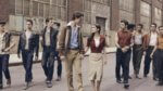 Two groups of teens on a New York Street with a young couple holding hand between them