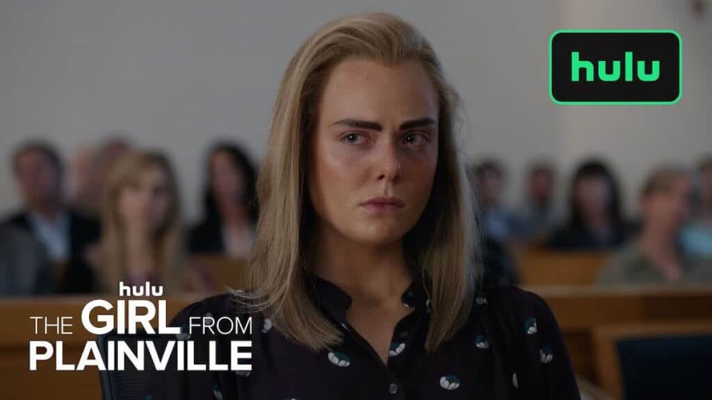 A girl sits in a courtroom looking off camera