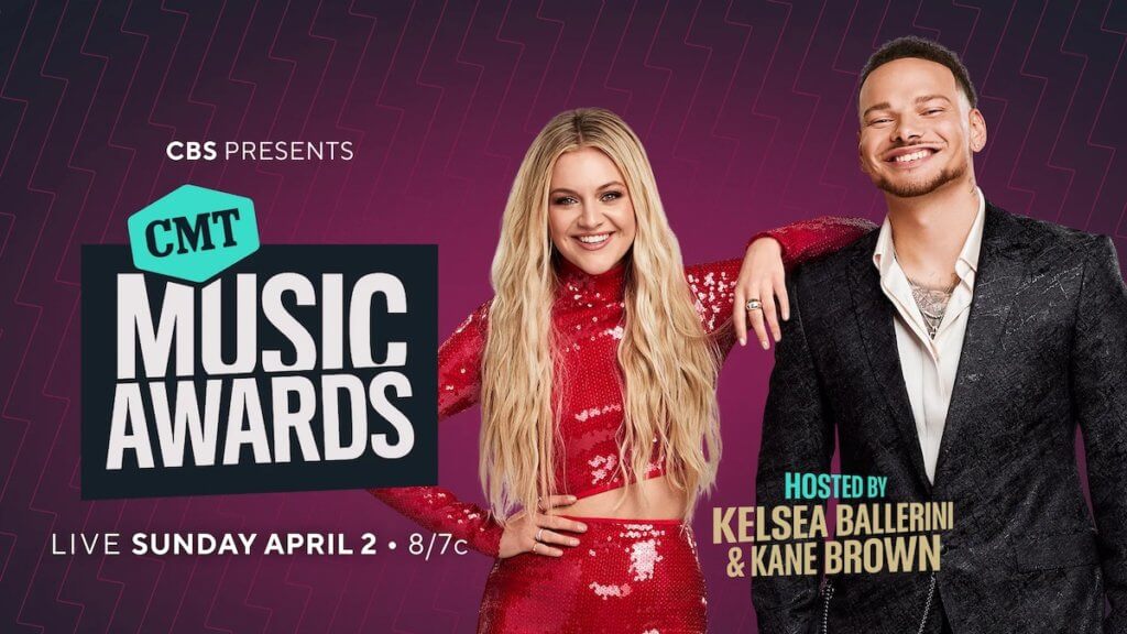 Man and woman cohosts of CMT Music Awards next to show title logo