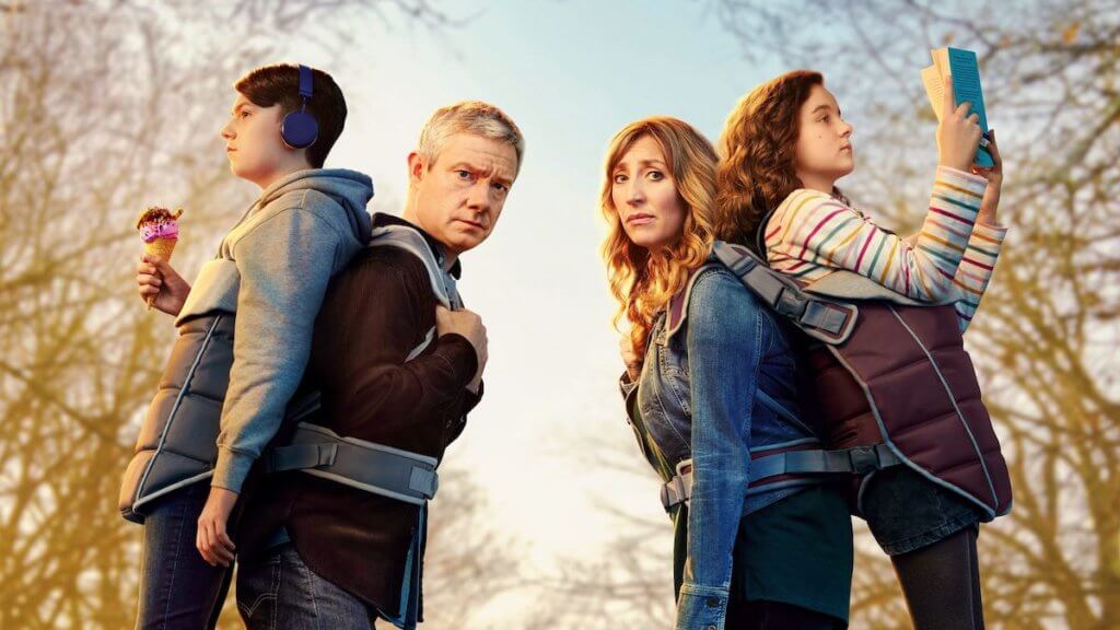 A couple with grown kids on their backs in baby carriers