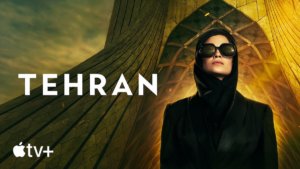 A woman in a dark dress and head covering with large dark sunglasses