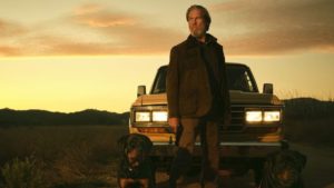 Jeff bridges and a dog in front of an old car