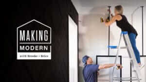 A woman on a ladder with a man supporting it