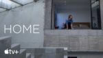 A man leaning through a window in a concrete modern home
