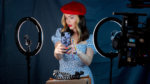 A woman staging a photo with ring lights