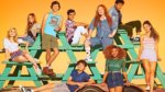 A group of teens posed on a stack of picnic tables
