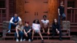 A group of queer teens on the steps of a cabin