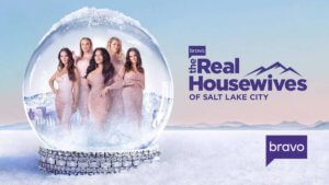 A group of five women in pink dresses in a snow globe