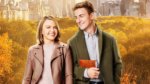 Young man and woman in front of autumn trees and NYC skyline