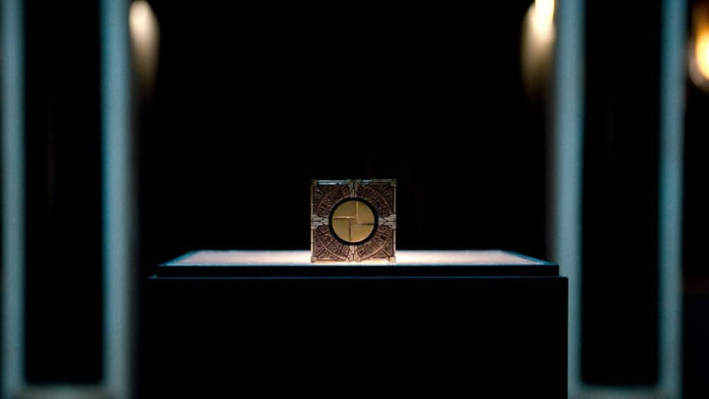 A mysterious puzzle box on a podium in a dark room