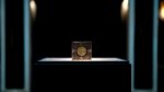 A mysterious puzzle box on a podium in a dark room