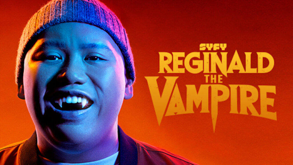 A young asian guy with vampire fangs and a beanie