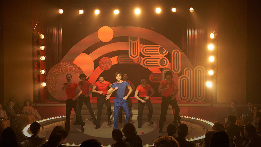 A group of men dancing in a 1970s style club stage