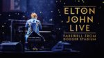 A rear shot of Elton John at a piano in concert