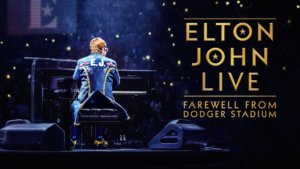 A rear shot of Elton John at a piano in concert