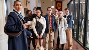 A group of posh prep school kids in a hallway turned in surprise looking past the camera