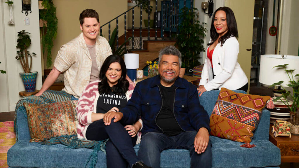 George Lopez and his daughter sit on a sofa with two other actors behind them