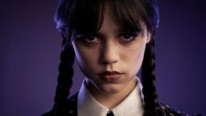 A young woman with dark hair in braids stares intently at camera