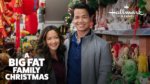 An Asian couple stands in front of a home full of holiday decorations