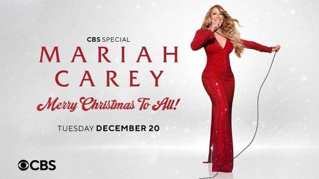 Mariah Carey holidng a microphone in a body con red sequined gown