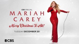 Mariah Carey holidng a microphone in a body con red sequined gown