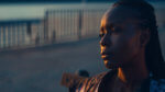 A young Black woman looking into the distance in the evening sunset light