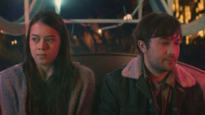 A couple sits uncomfortably on a Ferris wheel