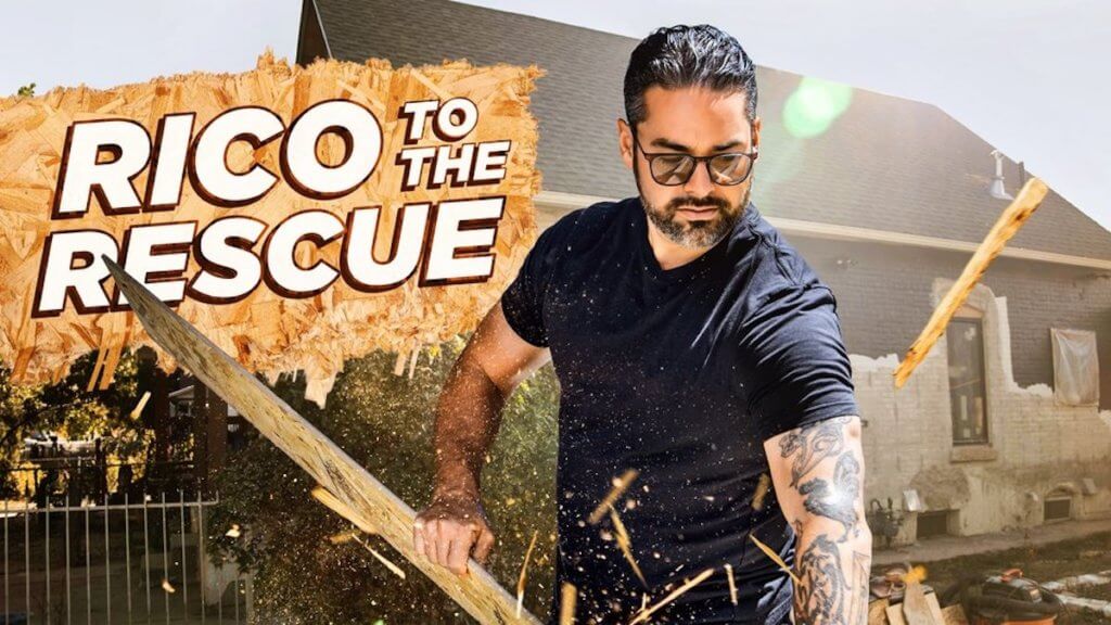 A tattooed contractor sawing up a piece of wood with cool protective shades 
