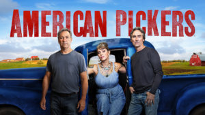 Three collectors stand in front of an old pick up in the american countryside