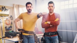 Twin brothers wearing tool belts in a workshop
