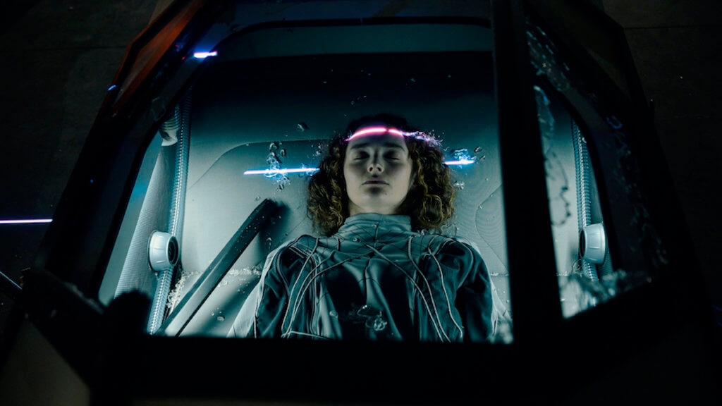 A woman appears asleep in a futuristic space pod