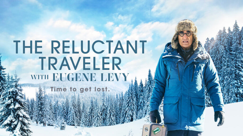 Actor Eugene Levy bundled up on a snowy mountainside looking anxious