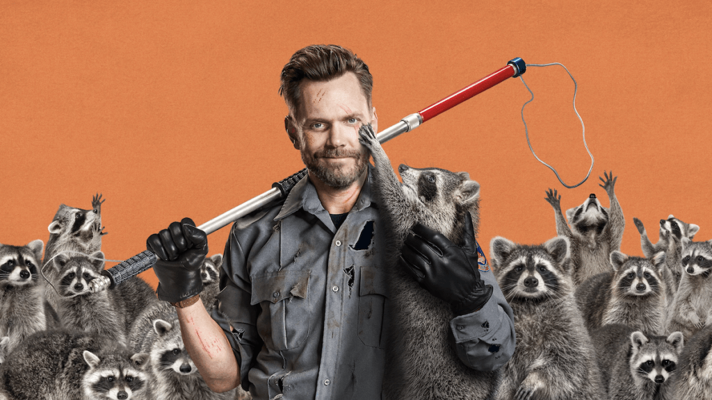 A man in animal control uniform holding a raccoon that is scratching his face, surrounded by dozens of other raccoons.