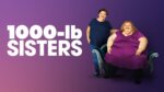 Two heavily overweight sisters, one seated, one smaller one standing, in front of a purple background.