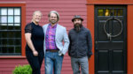 Three housing pros stand in front of a history home