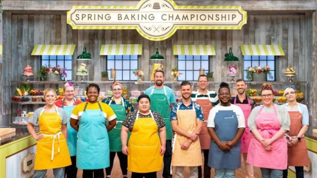 A group of 12 bakers in pastel aprons in a cute country kitchen