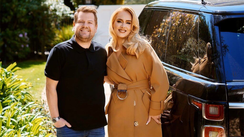 Comedian and performer James Corden with music icon Adele standing by a car