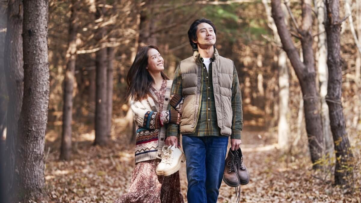 A young Asian couple walks through a romantic forest