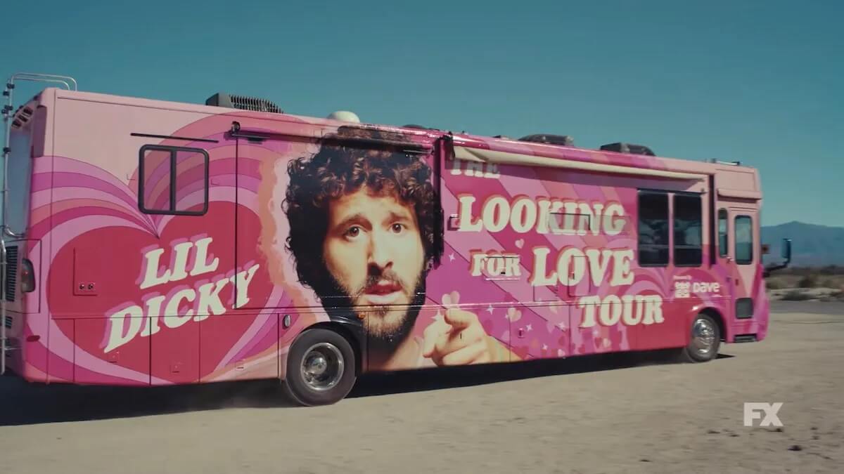 A large pink tour bus with a man's face on it and "Lil Dickey Looking for Love Tour" written on it.