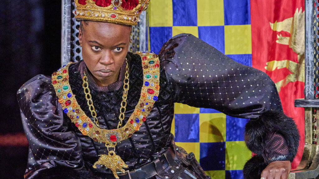 A Black woman dressed in Medieval royalty as a king